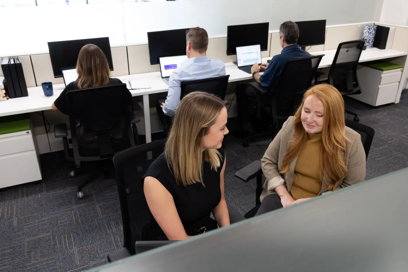 A quiet conversation in the open-plan office.