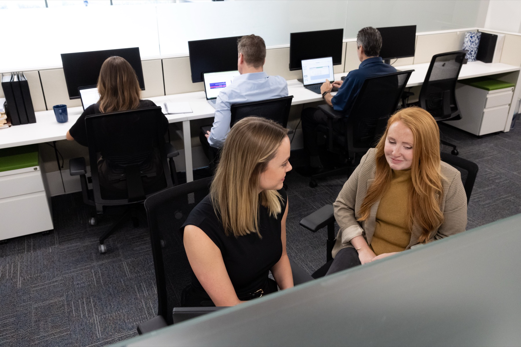 Colleagues working and talking in the Clarkston office.